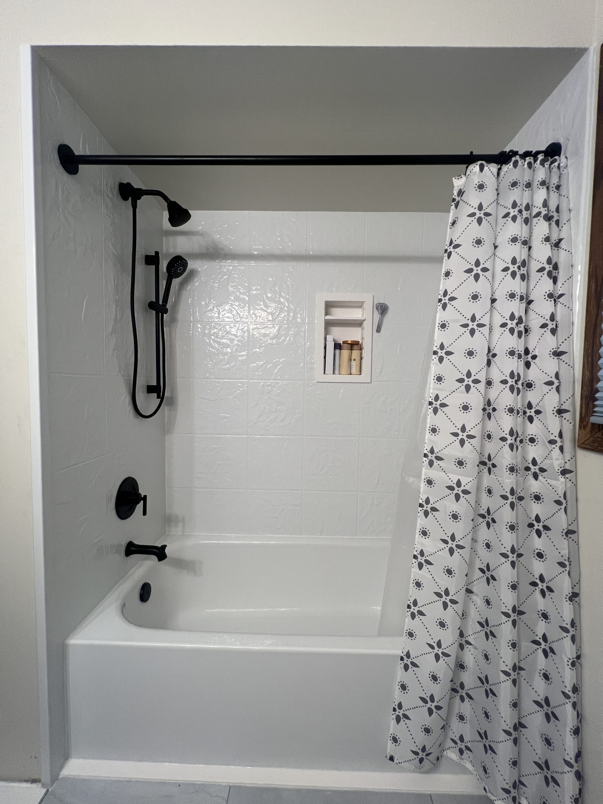 New white bathtub remodel with black hardware