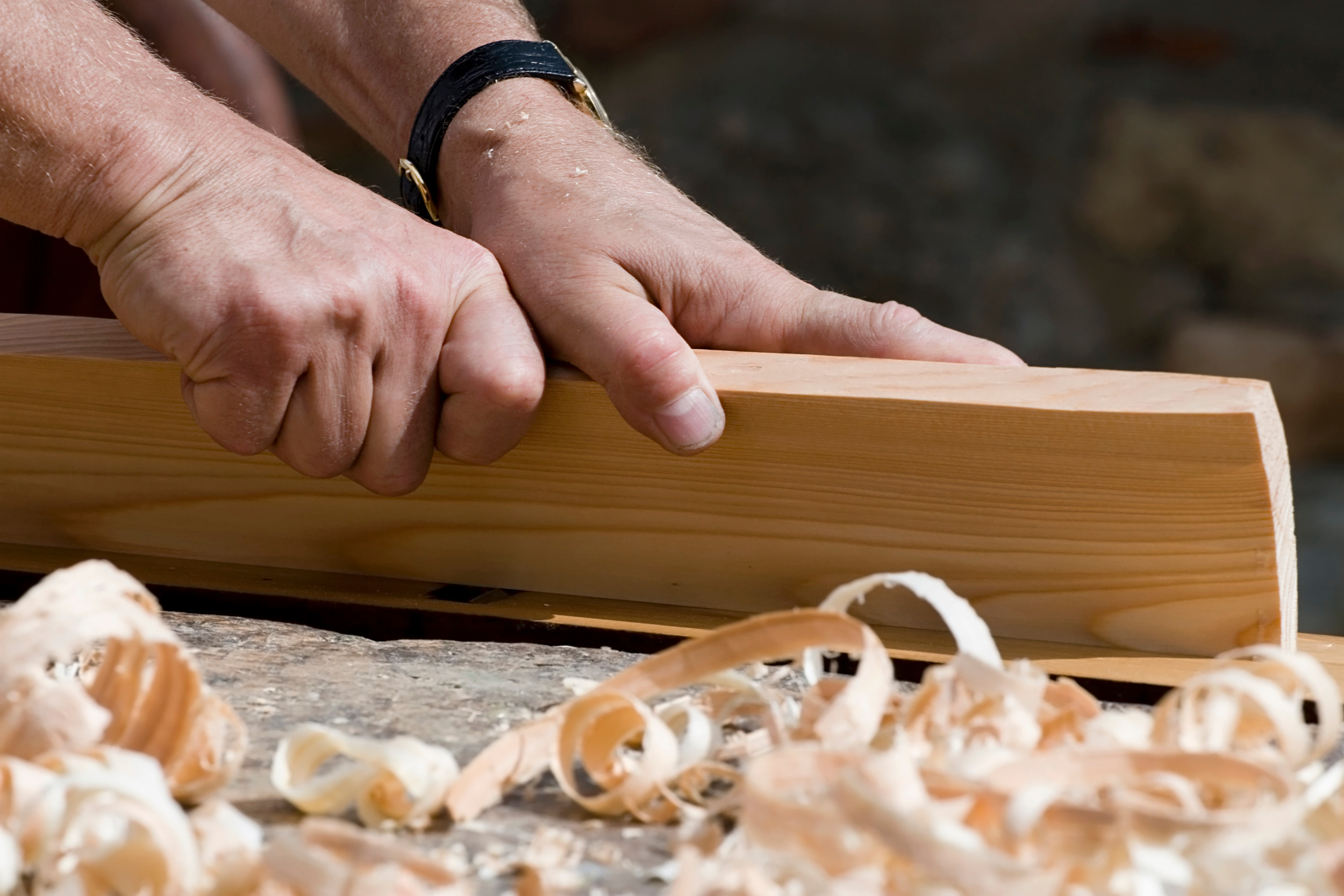 Close up of woodworking hands and wood shavings