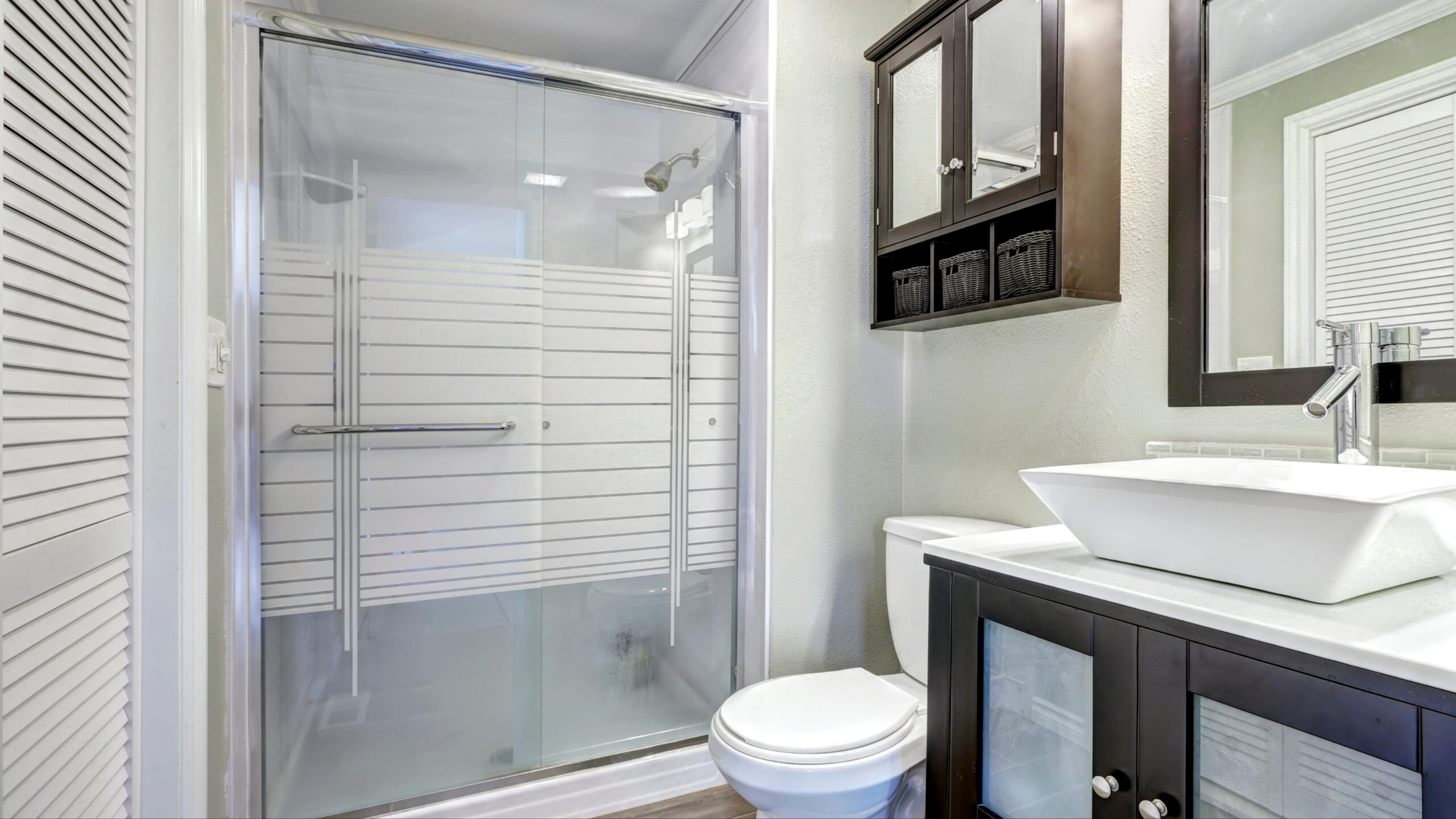 A walk-in shower with glass doors