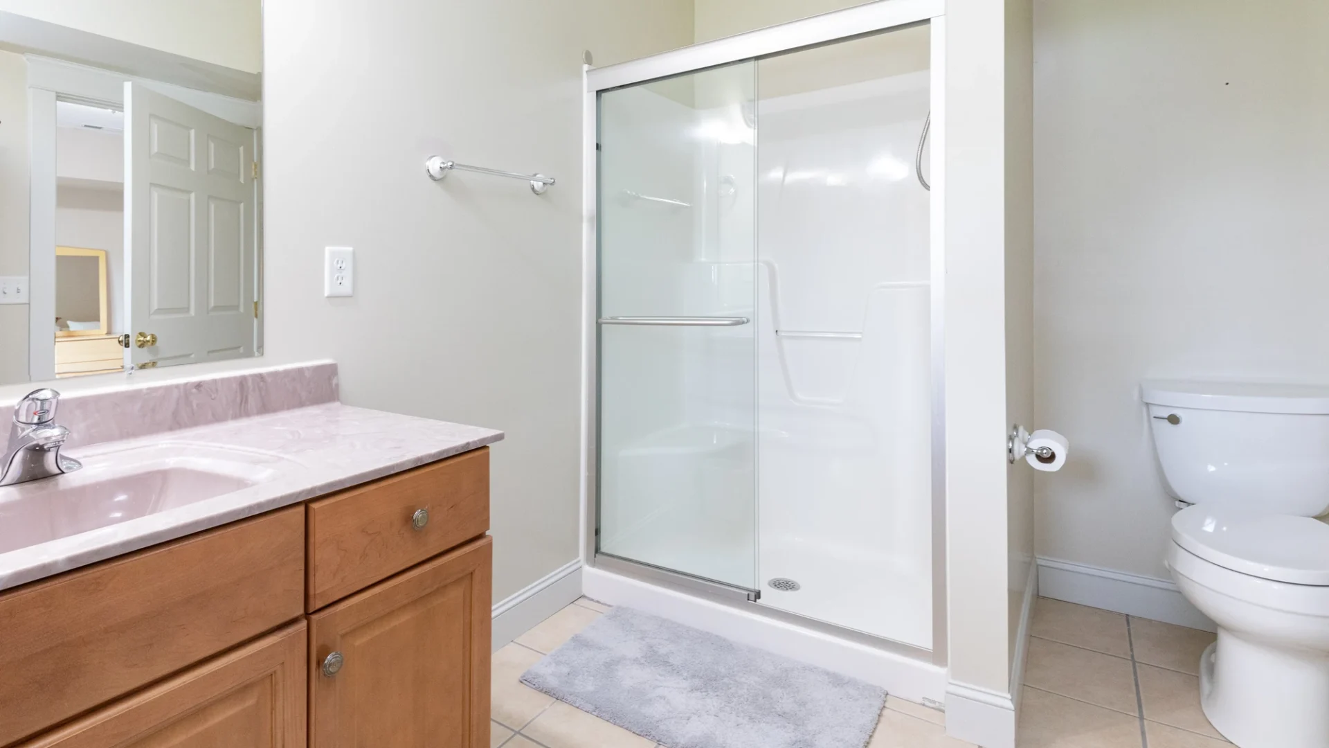 Bathroom with white shower with sliding glass door and white interior